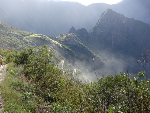 A herd of buses taking people down the mountain on the hair raising, multiple switchbac dirt road kicked up a cloud of dust like an early morning mountain fog.